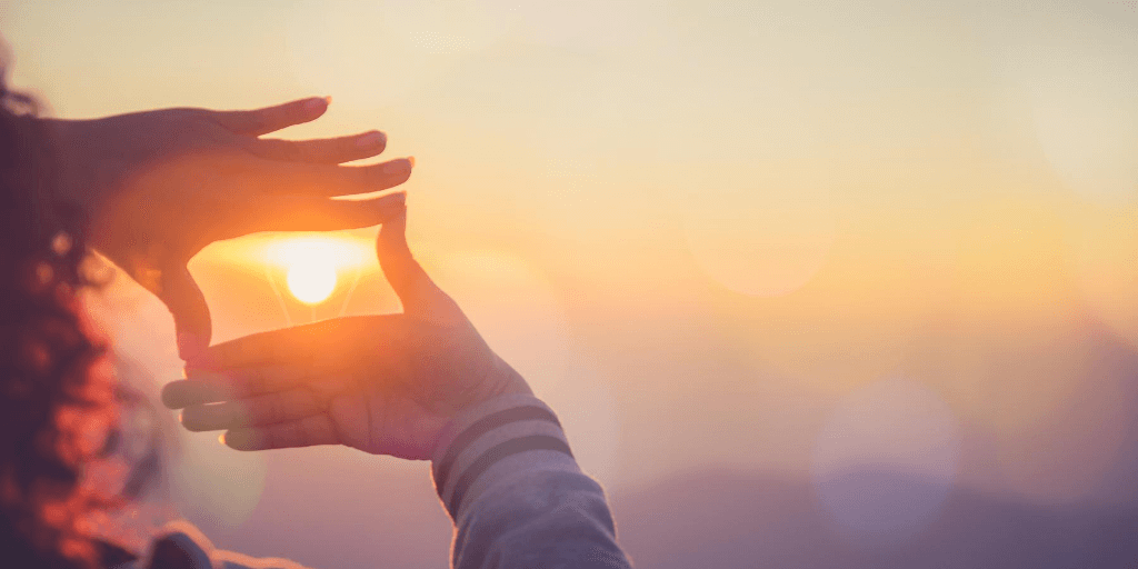 hands framing sunset